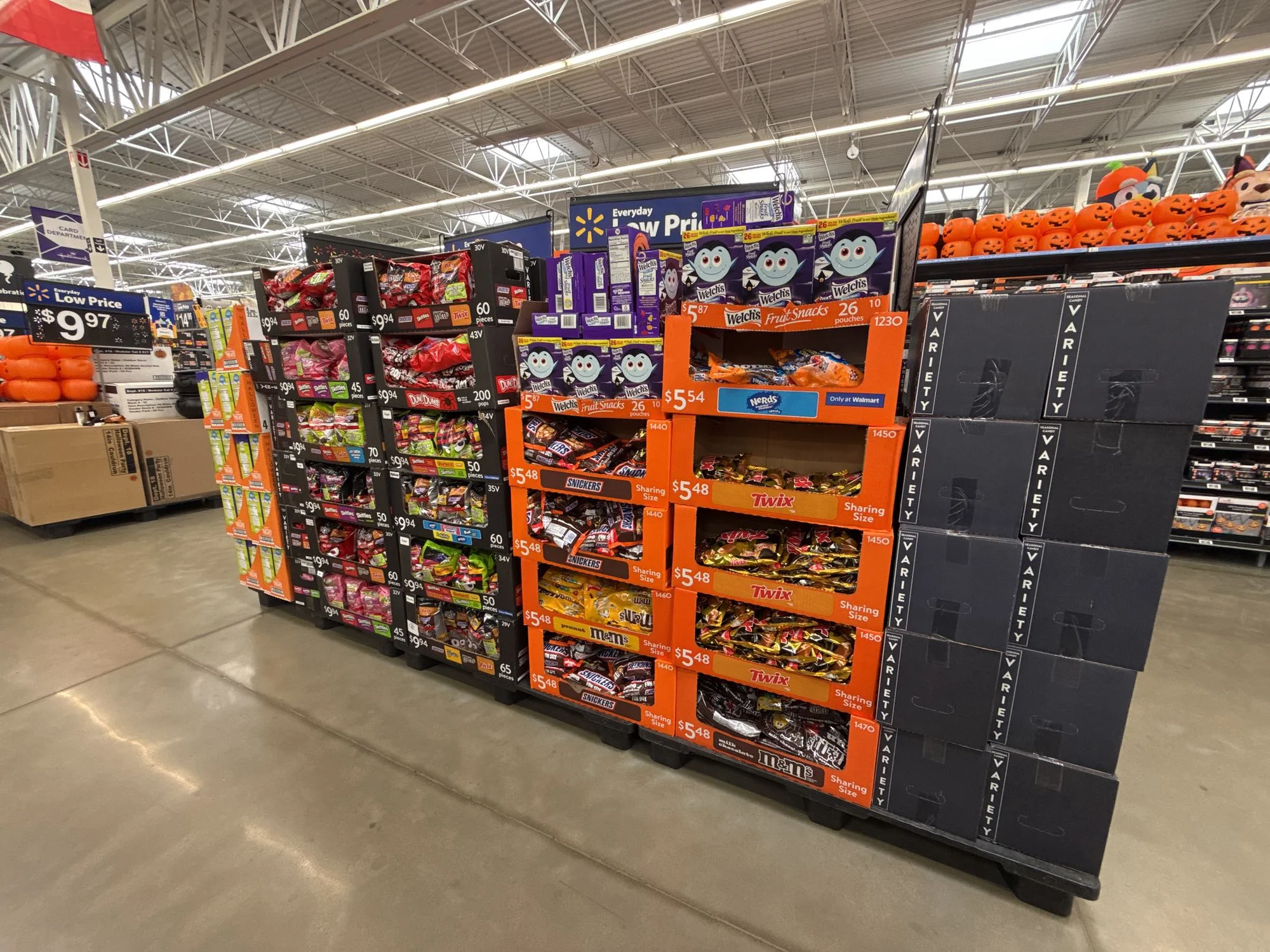 Pallets of Halloween candy (Snickers, Twix, M&M's, Skittles) in a Walmart store